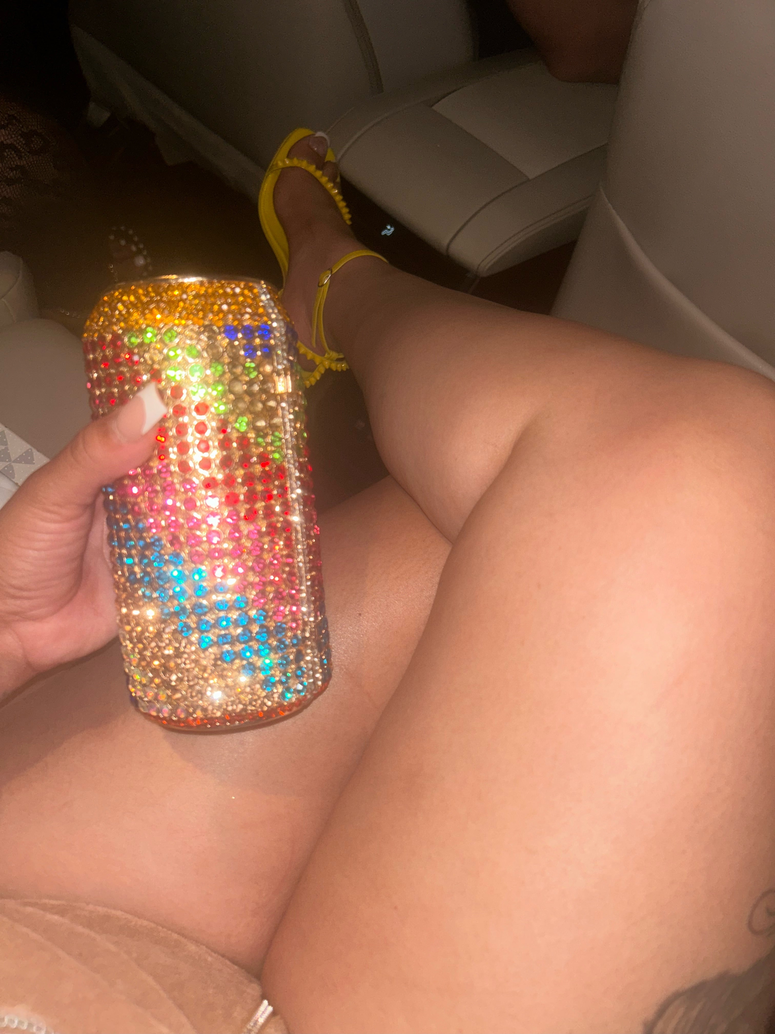 A sparkling, rhinestone-encrusted clutch in the shape of a soda can, featuring vibrant multicolored gems, a sleek metallic finish, and a detachable chain strap for versatile wear